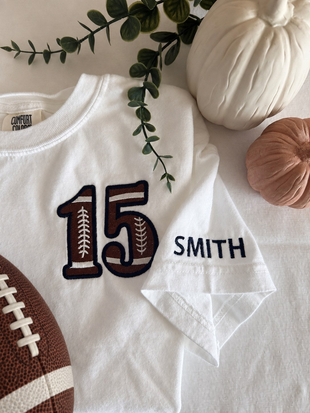 Sample: football-style number 15 on the left chest, shown with the optional sleeve name SMITH