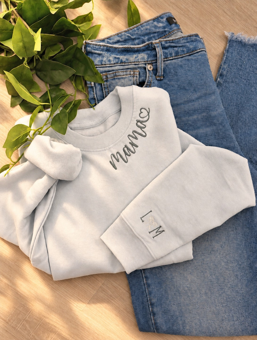 Sample: mama embroidered along the neckline, with the initials L and M and a bow on the cuff in Benjamin lettering
