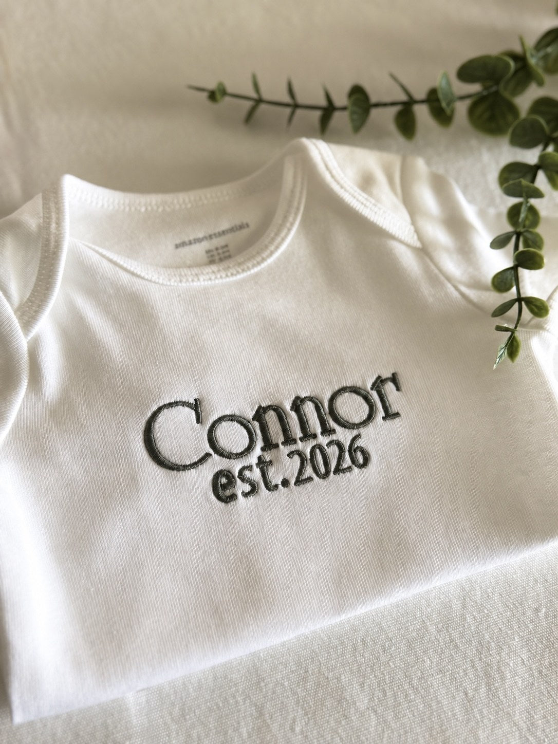 Sample: Connor est. 2026 embroidered in the University font, thread 0238