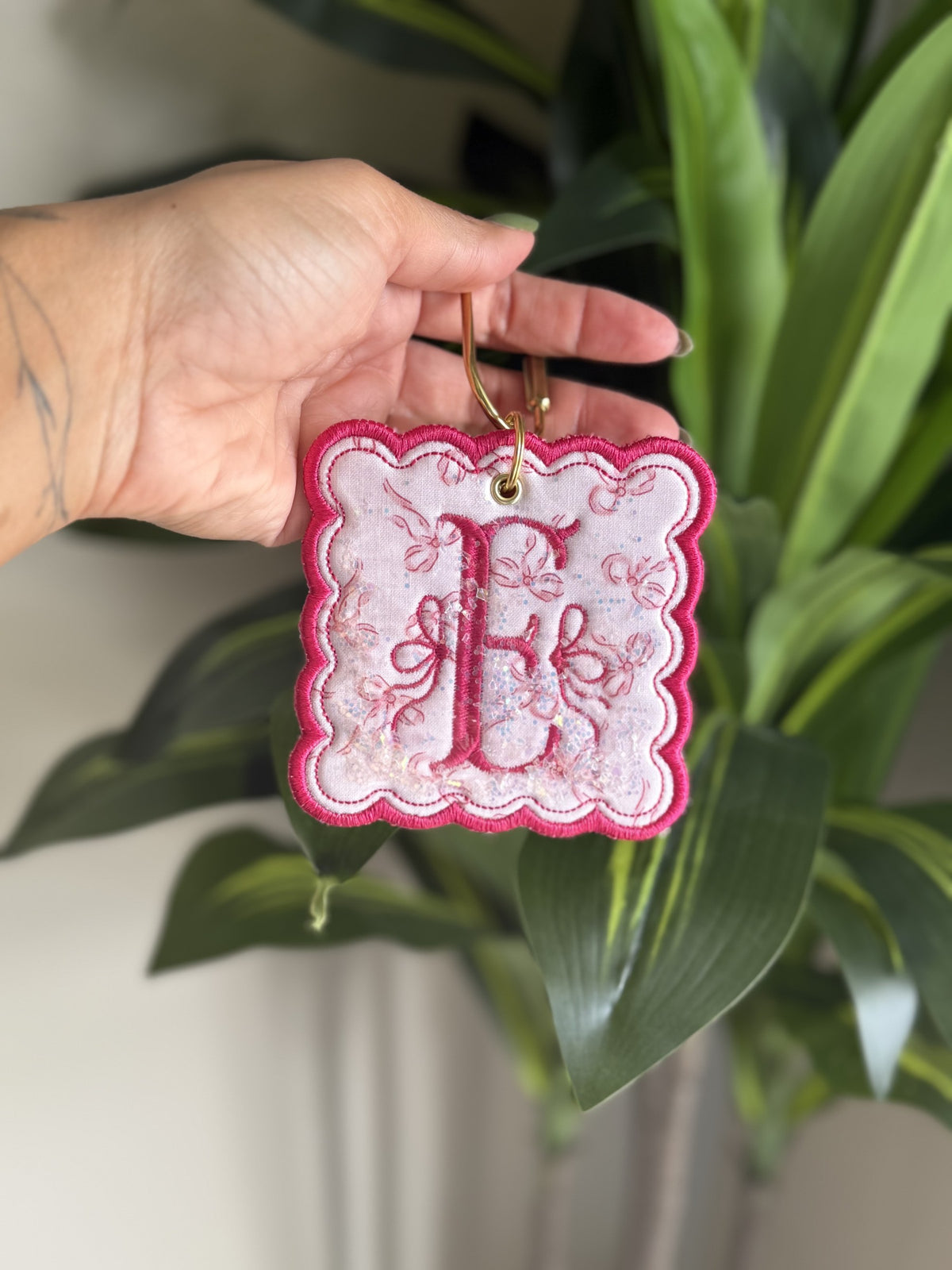 Sample: initial E with bows, pink thread and scalloped pink border